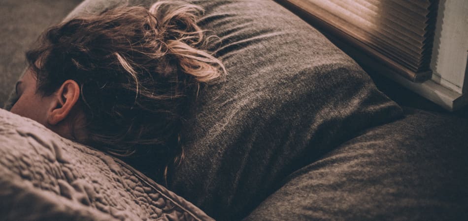 Een vrouw die ziek in bed ligt