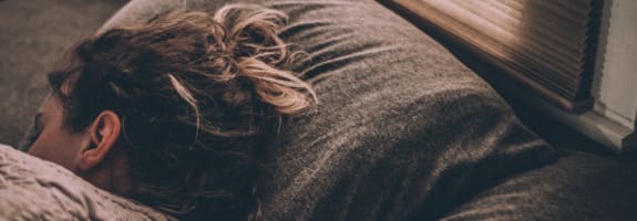 Vrouw met haar hoofd tussen haar handen op het bureau