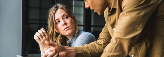 man en vrouw die op het werk met elkaar in gesprek zijn