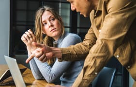 man en vrouw die op het werk met elkaar in gesprek zijn