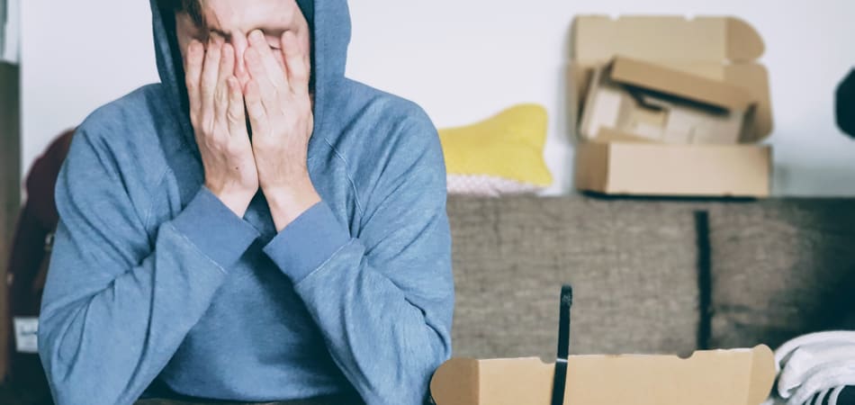 man die twee handen voor zijn gezicht houdt