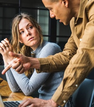 man en vrouw die op het werk met elkaar in gesprek zijn