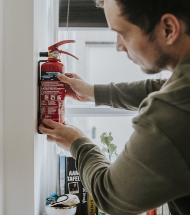 Man hangt brandblusser aan de muur