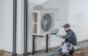 Monteur geeft onderhoudsbeurt aan een warmtepomp