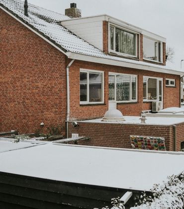 Een rij huizen met sneeuw op het dak