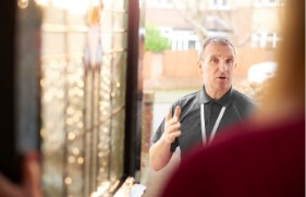 Man met keycord die aan de deur staat en aan het praten is