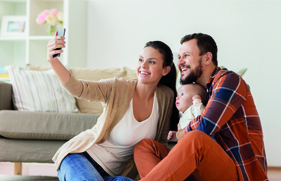 Man en vrouw met hun baby die met een smartphone een foto maken