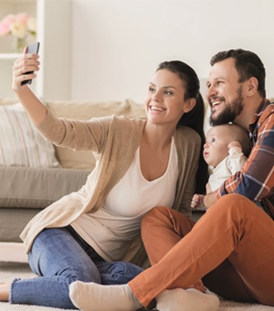 Man en vrouw met hun baby die met een smartphone een foto maken