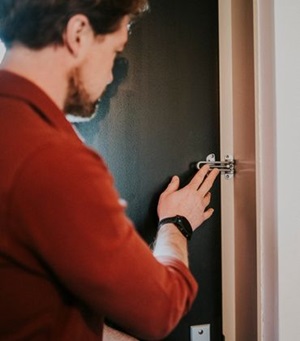 Man heeft een veiligheidsslot op zijn voordeur, naast het gewone slot