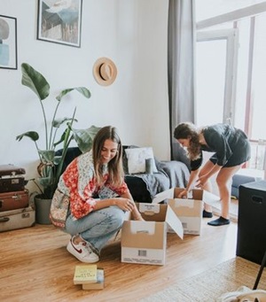 2 meiden pakken verhuisdozen in