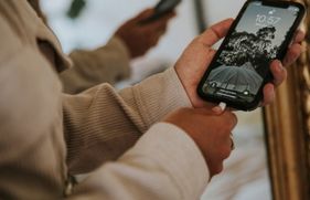 Iemand steekt de laadkabel in de oplaadpoort van een smartphone.