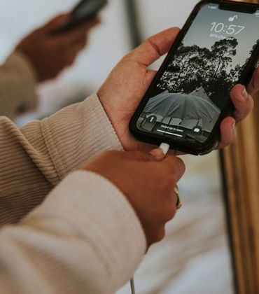 Iemand steekt de laadkabel in de oplaadpoort van een smartphone.