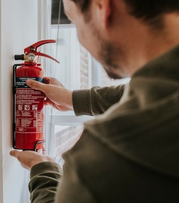 Man pakt een brandblusser van de muur