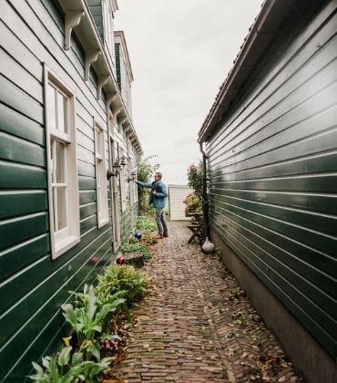 Man belt aan bij houten huis. Tips om jouw huis brandveilig te maken.