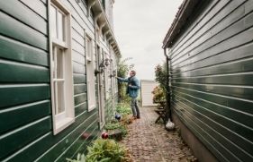 Man belt aan bij houten huis. Tips om jouw huis brandveilig te maken.