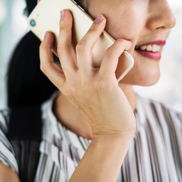 Vrouw belt met telefoon in haar hand.